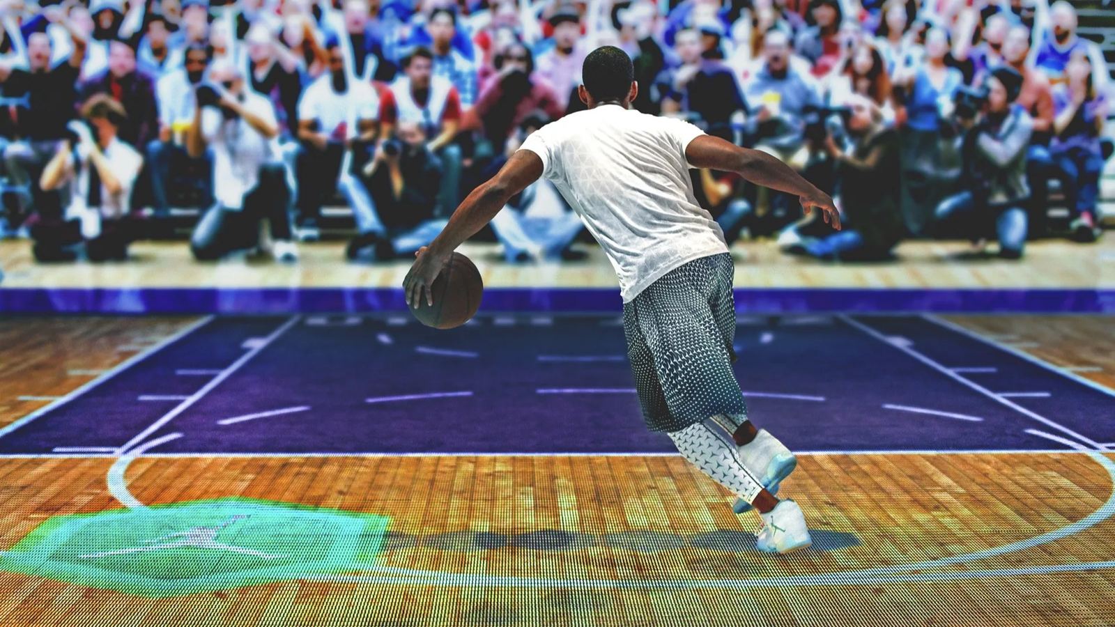 A player dribbles toward a projected crowd of photographers