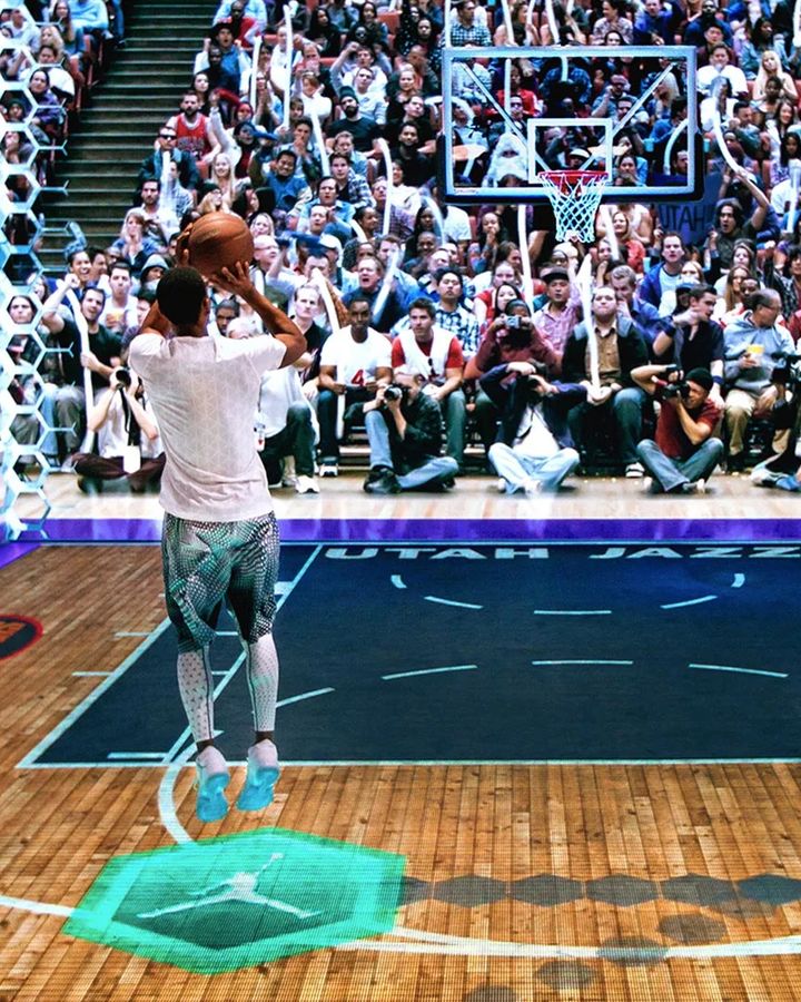 A player takes a buzzer-beater on the LED court as a projected crowd watches