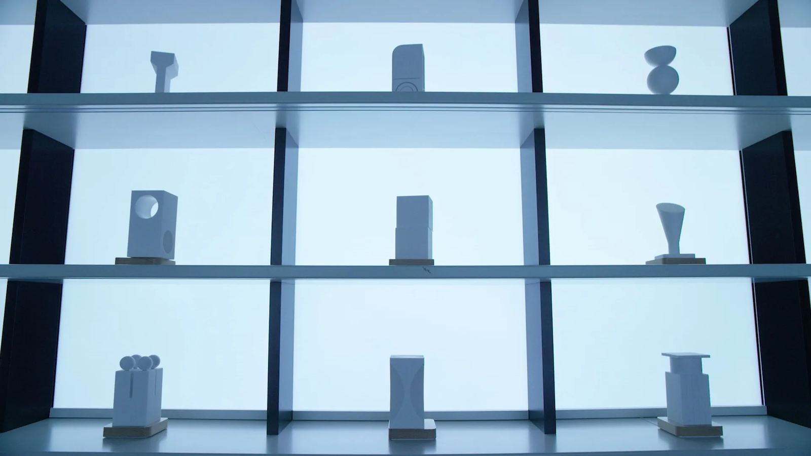 Nine white smart objects on a backlit display shelf