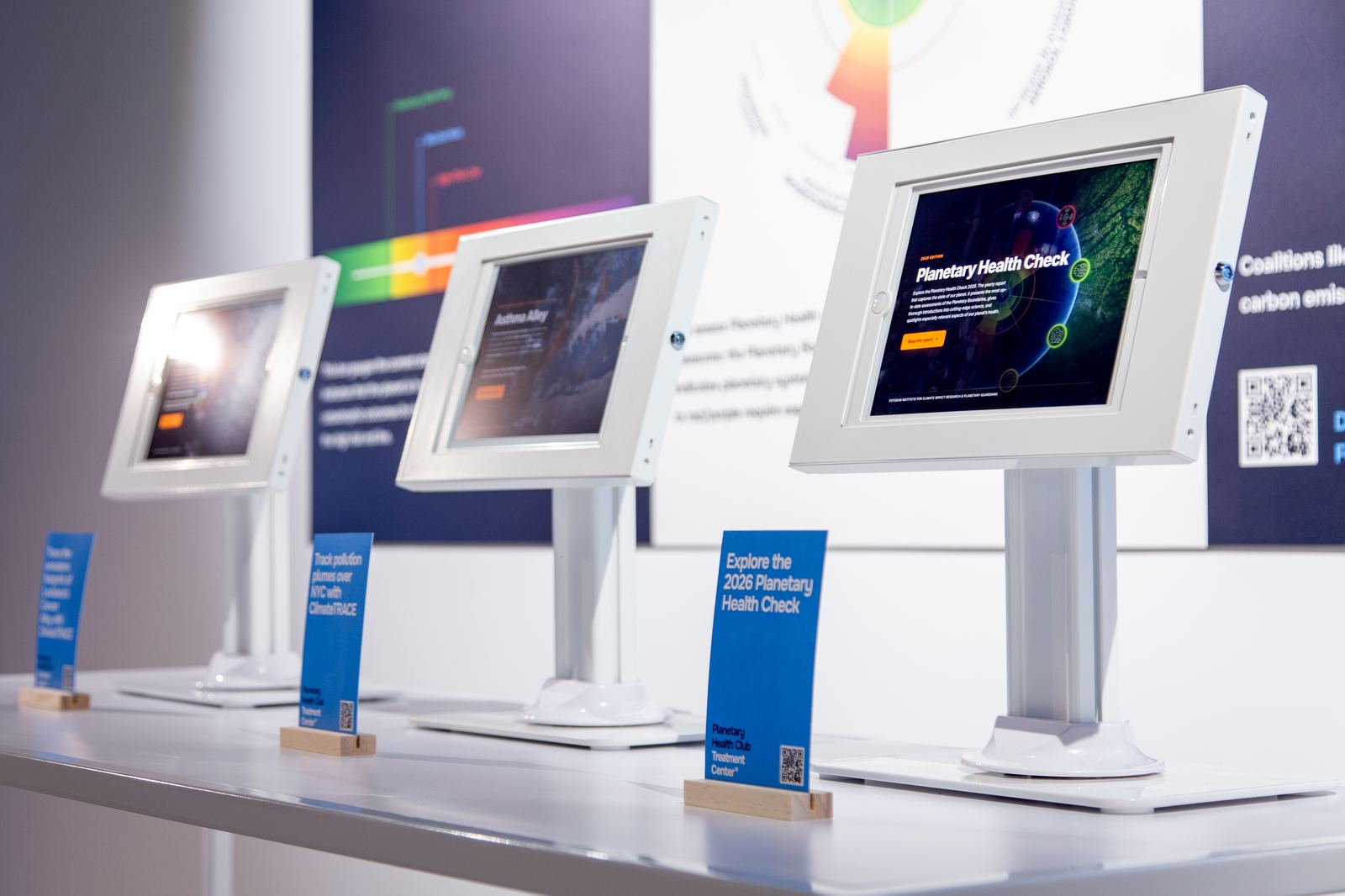 iPad stations showing the Planetary Health Check 2026 and Climate TRACE data