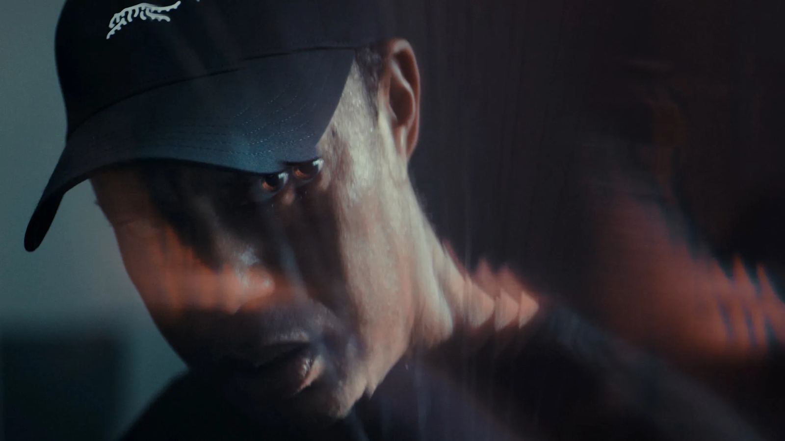 Motion-blurred close-up of Tiger Woods in a Sun Day Red cap