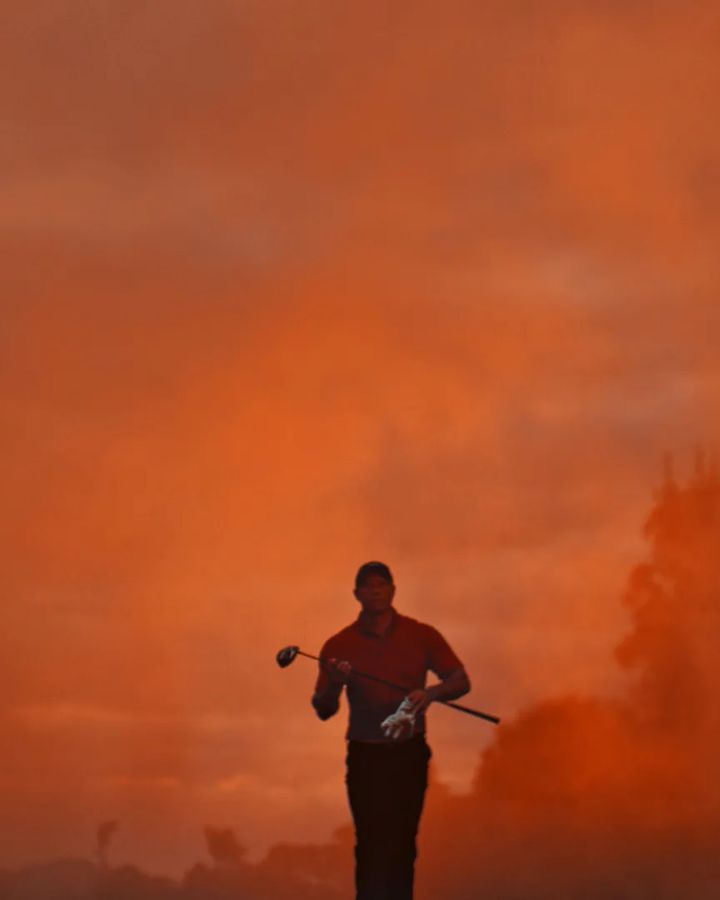 A golfer walks out of red smoke at dawn, from the Sun Day Red launch film